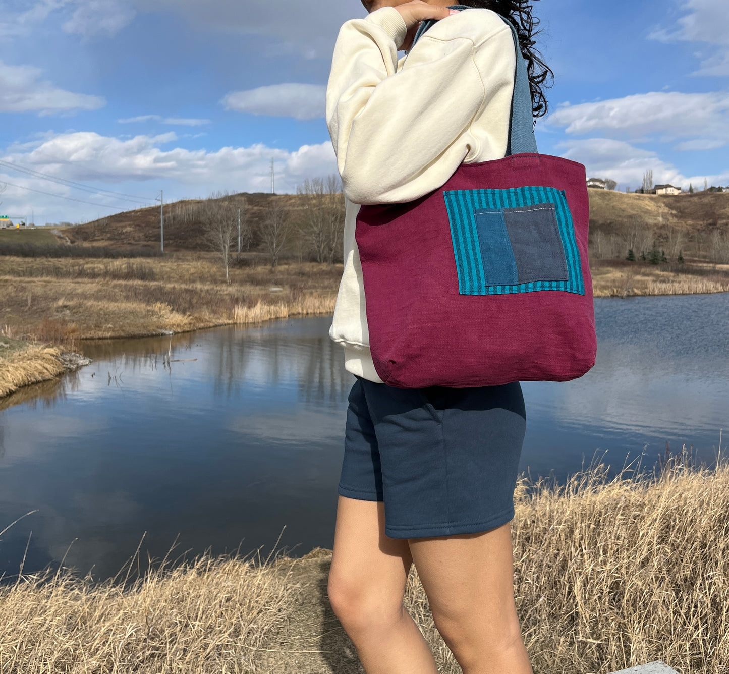 Close up of our blue and crimson tote on a model.