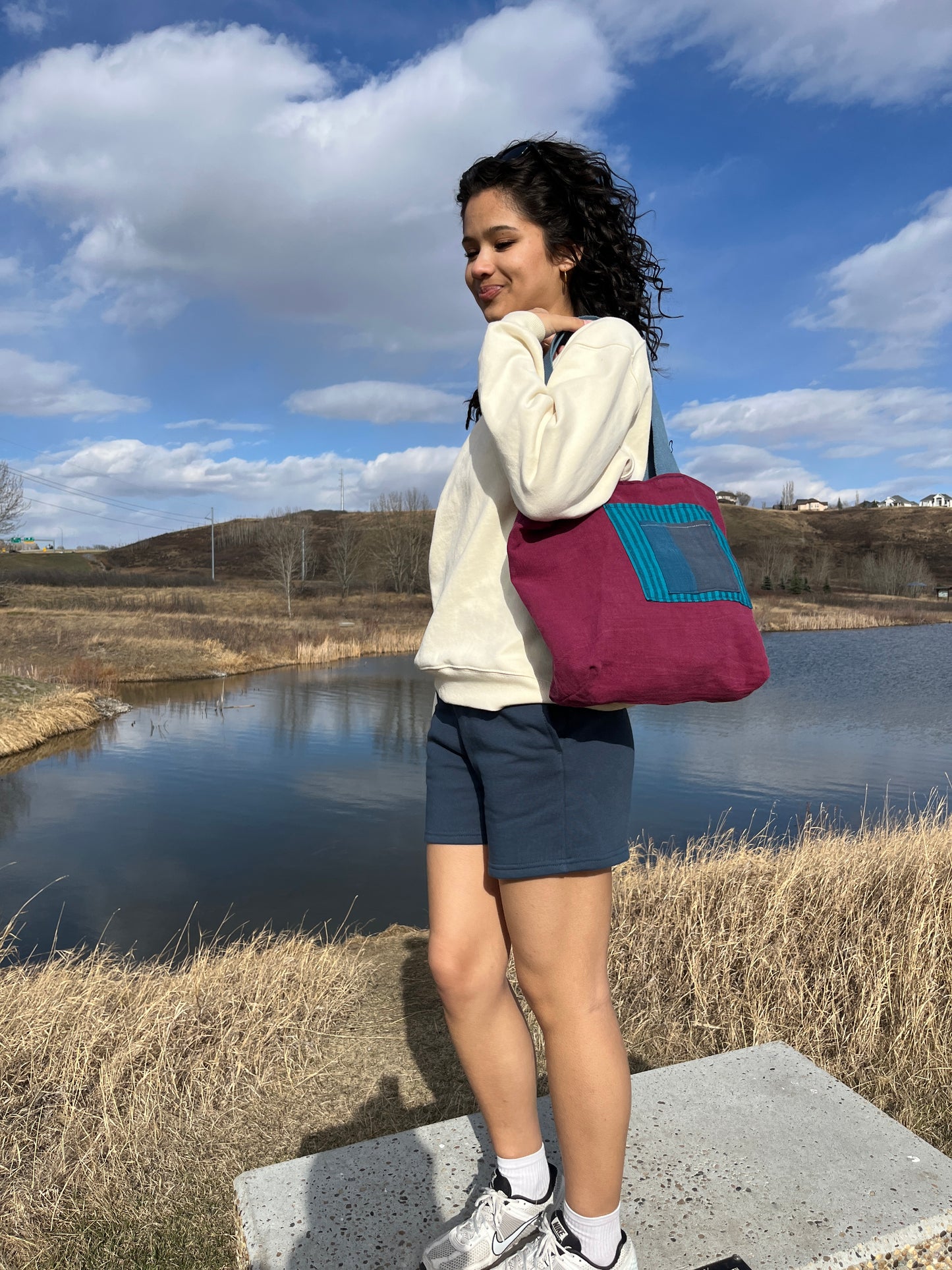A model showing our blue and burgundy linen tote.