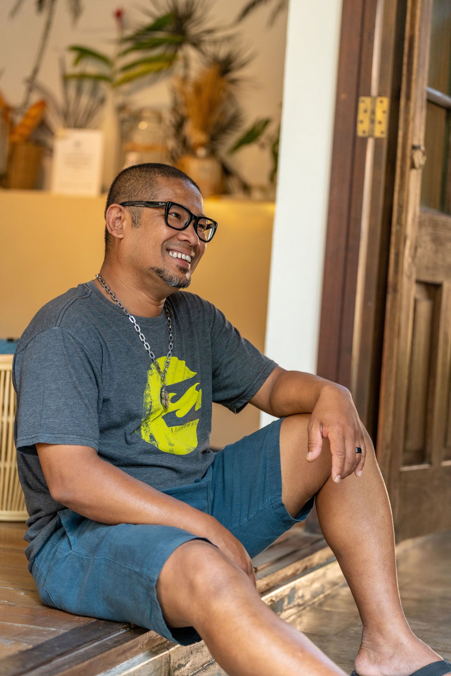 Male model wearing our men's linen shorts in Petrol, blue-green color.