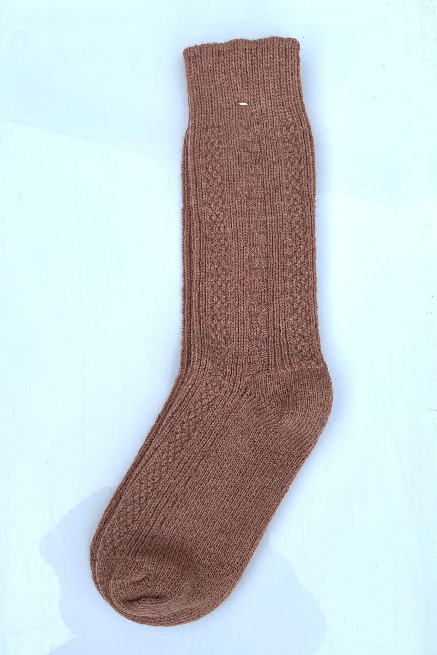 Beige color merino wool crew socks, laying flat.