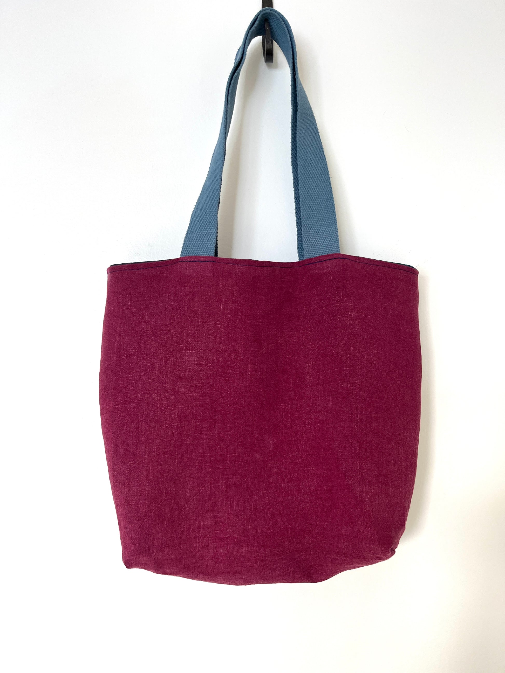 The burgundy side of a reversible linen tote bag.