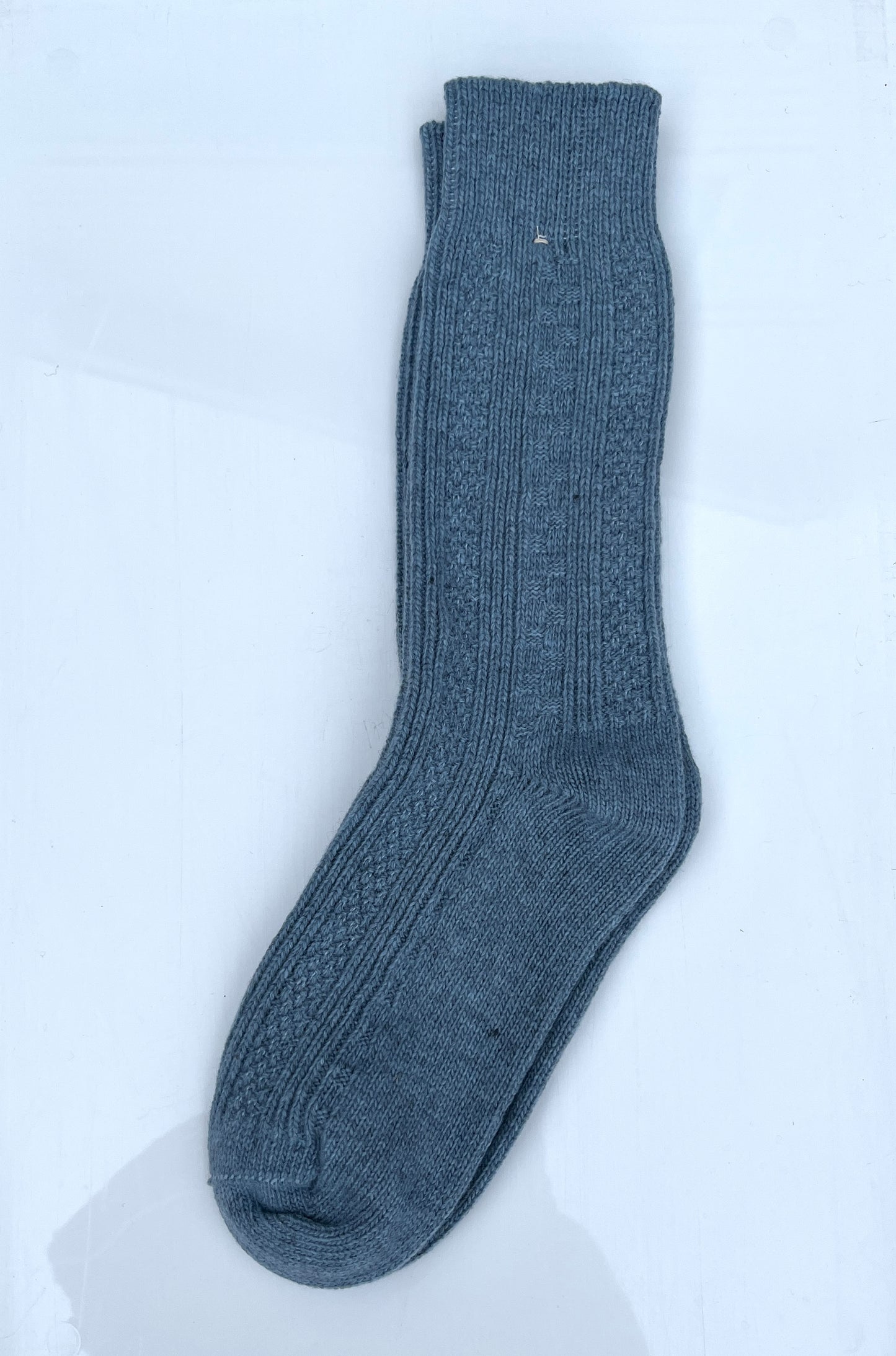 Light blue color merino wool crew socks, laying flat.