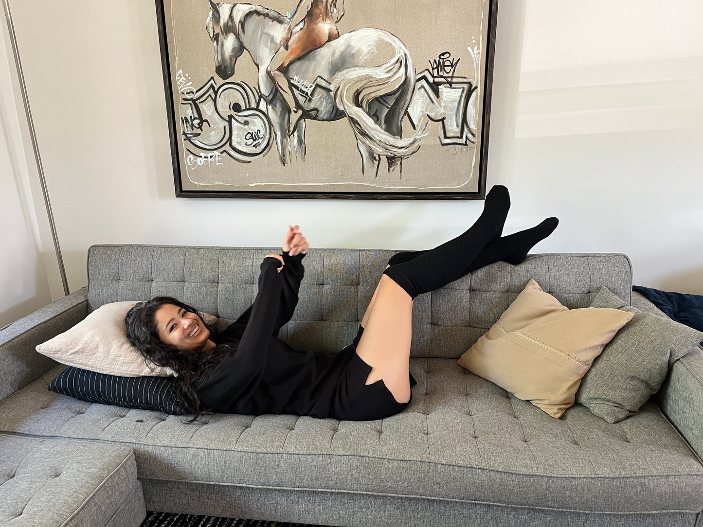 Woman having fun wearing our black organic cotton waffle set and merino wool knee socks. 