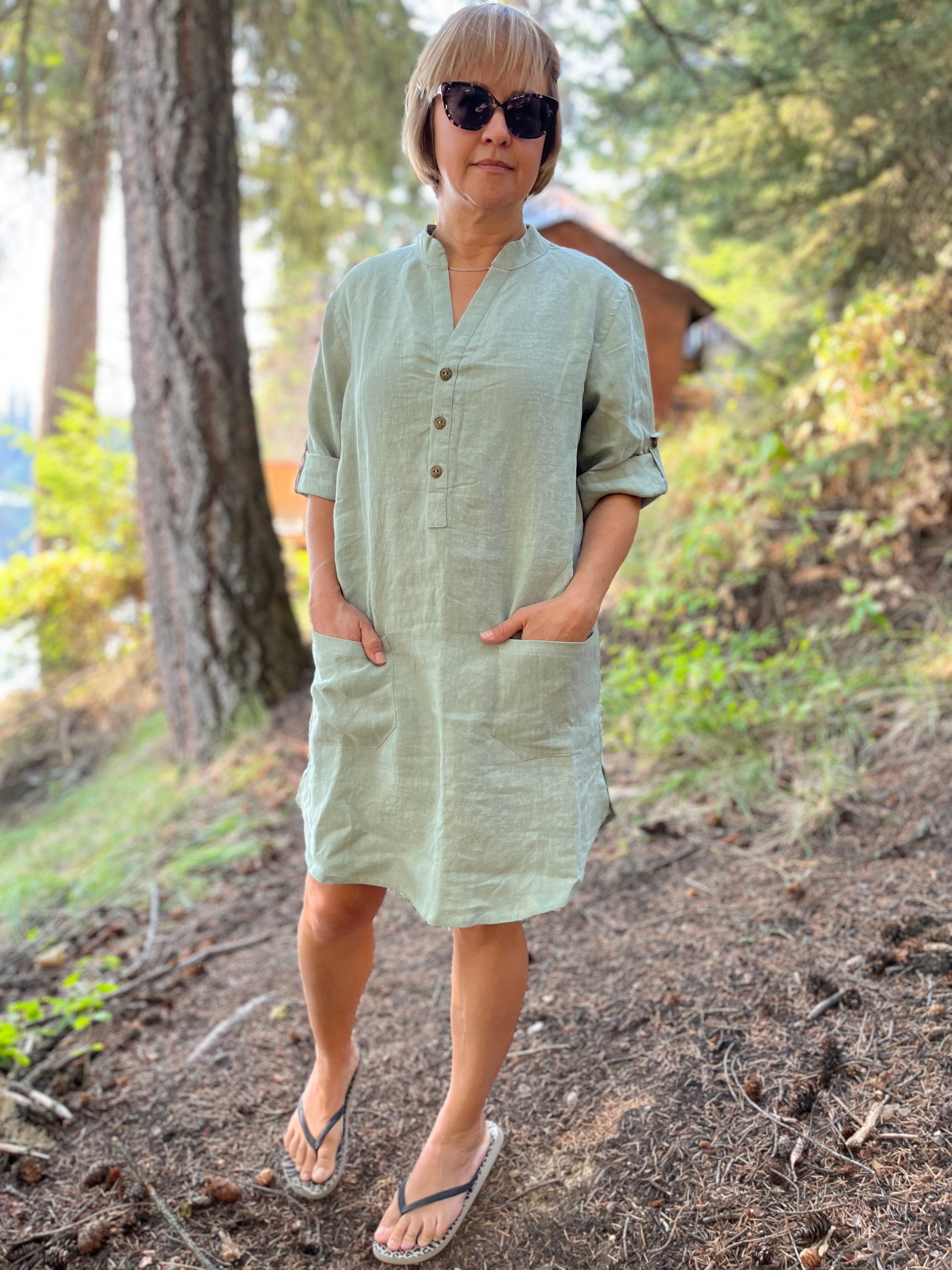 Woman wearing short version linen shirt dress in seafoam color.