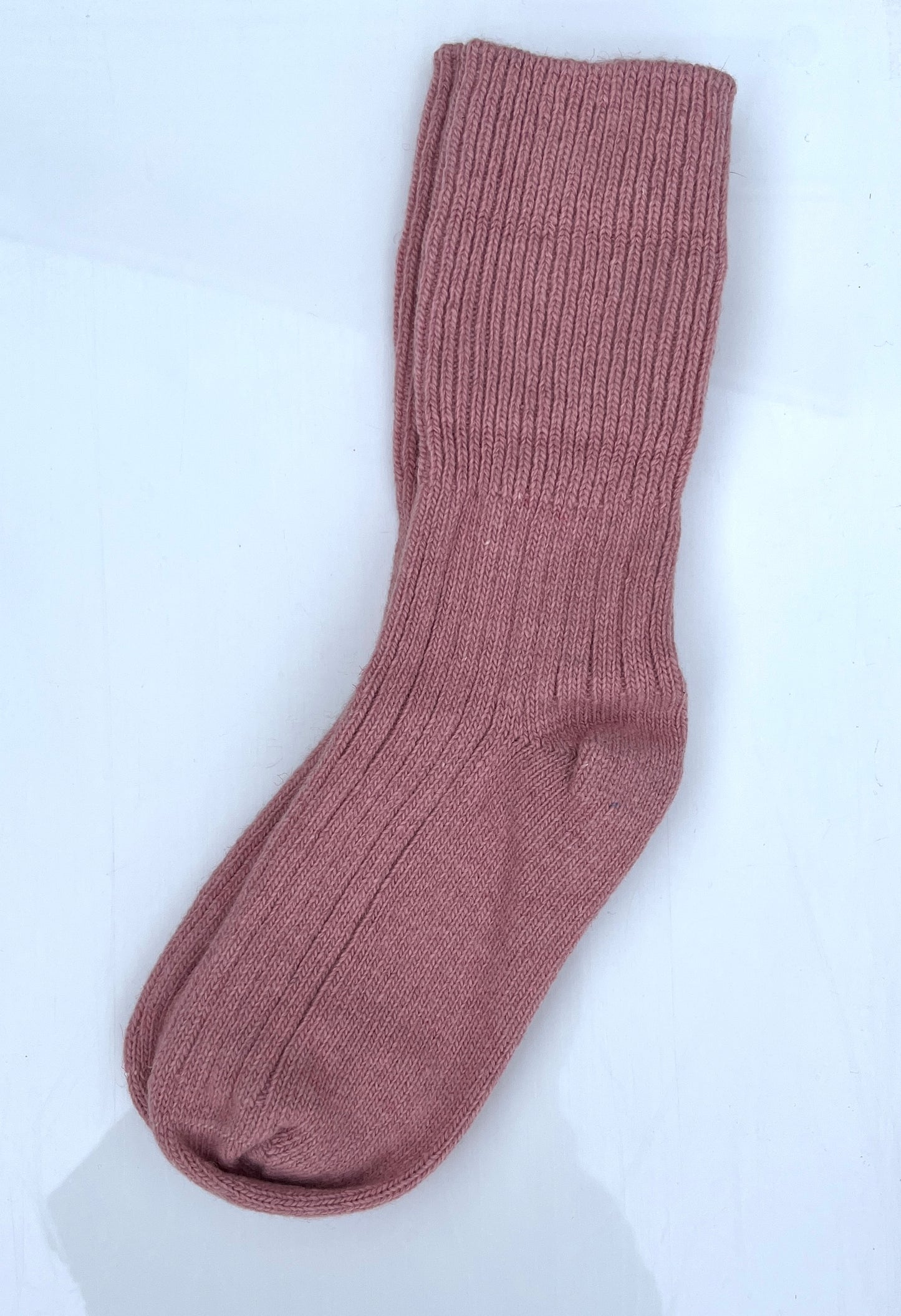 Light pink color merino wool crew socks, laying flat.